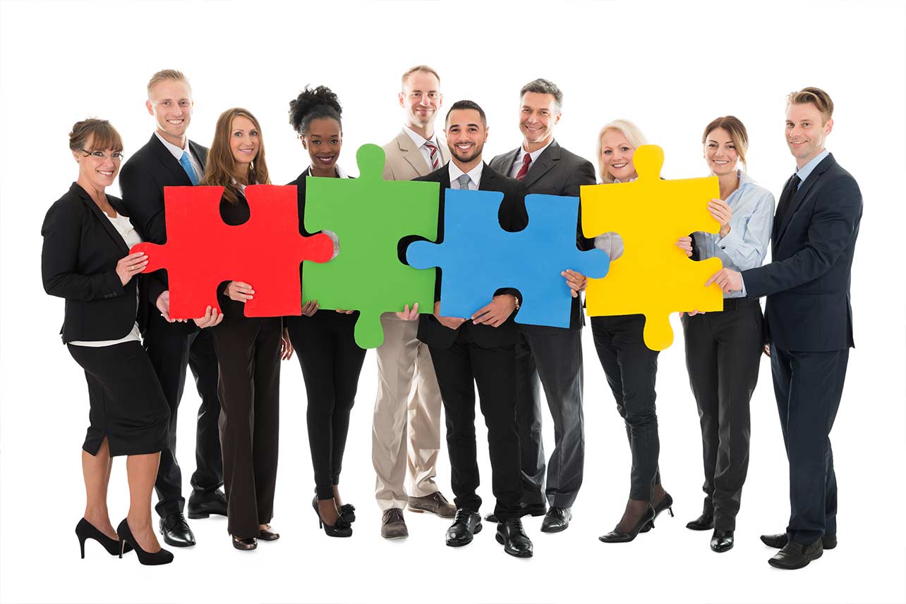 group of people holding colorful puzzle pieces