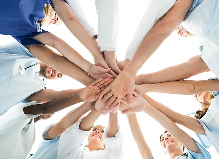 nurses putting hands together in circle