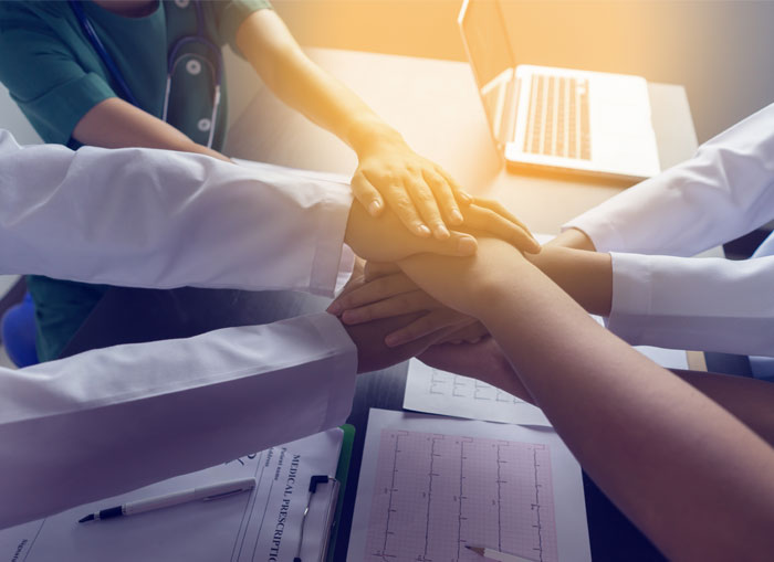 medical workers with hands together in center