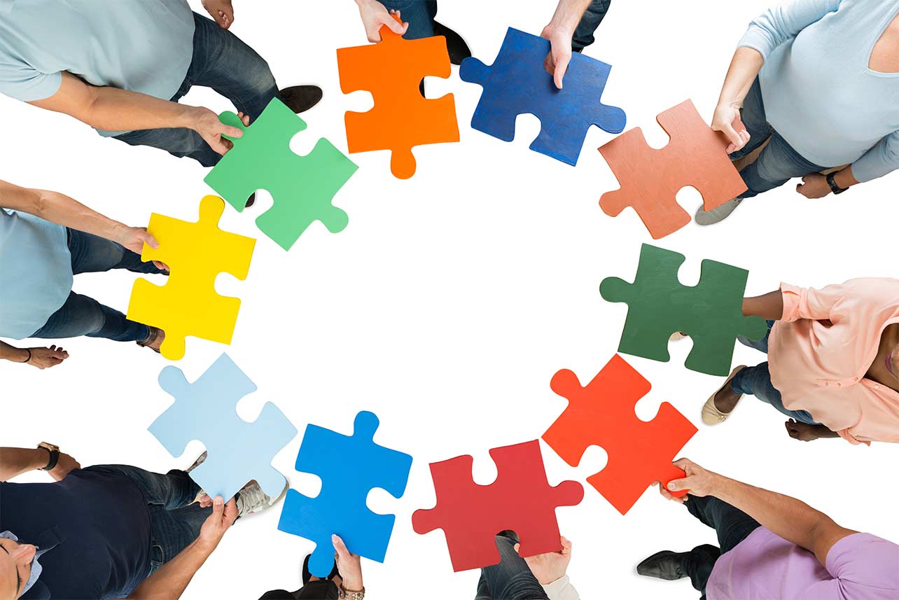 overhead view of hands holding colorful puzzle pieces